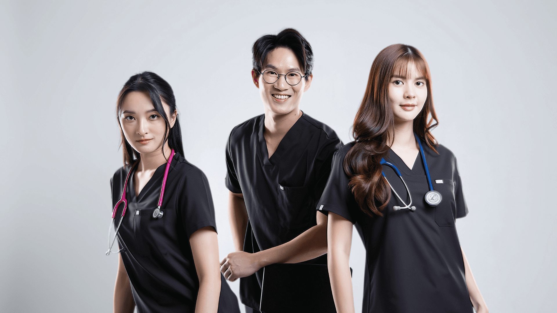 Three healthcare professionals wearing scrub uniforms